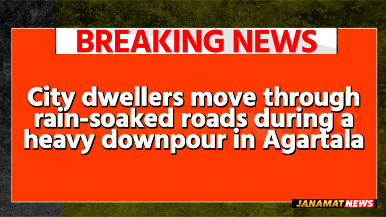 City dwellers move through rain-soaked roads during a heavy downpour in Agartala on May 26. |