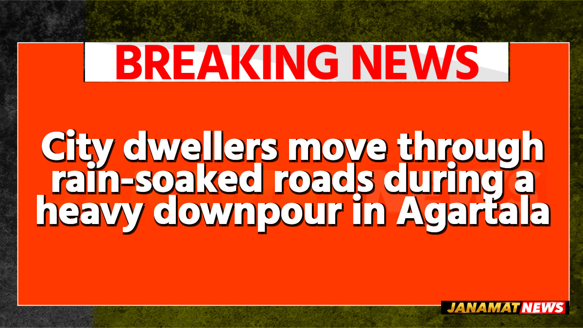 City dwellers move through rain-soaked roads during a heavy downpour in Agartala on May 26. |